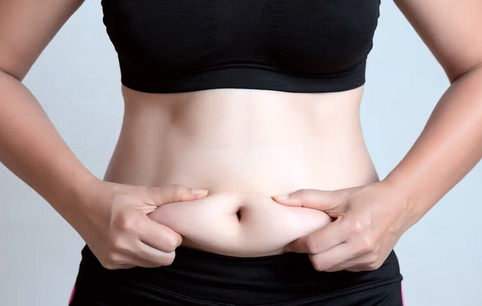 une femme tiens son ventre dans ses mains car elle veut maigrir du ventre